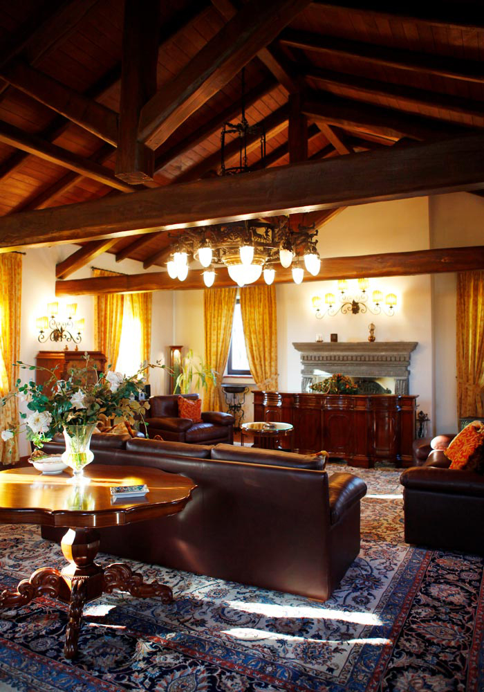 Hall with wooden beam ceiling, leather sofas and fireplace, for corporate events at the charme residence