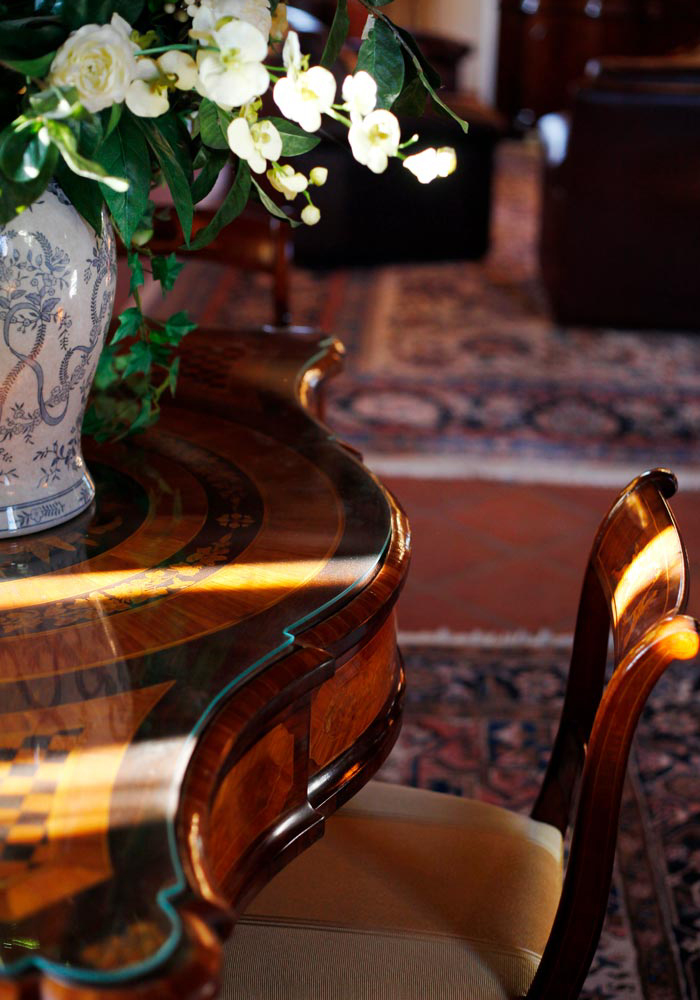 Inlaid period table with floral arrangement, a business hall detail in Lumellogno