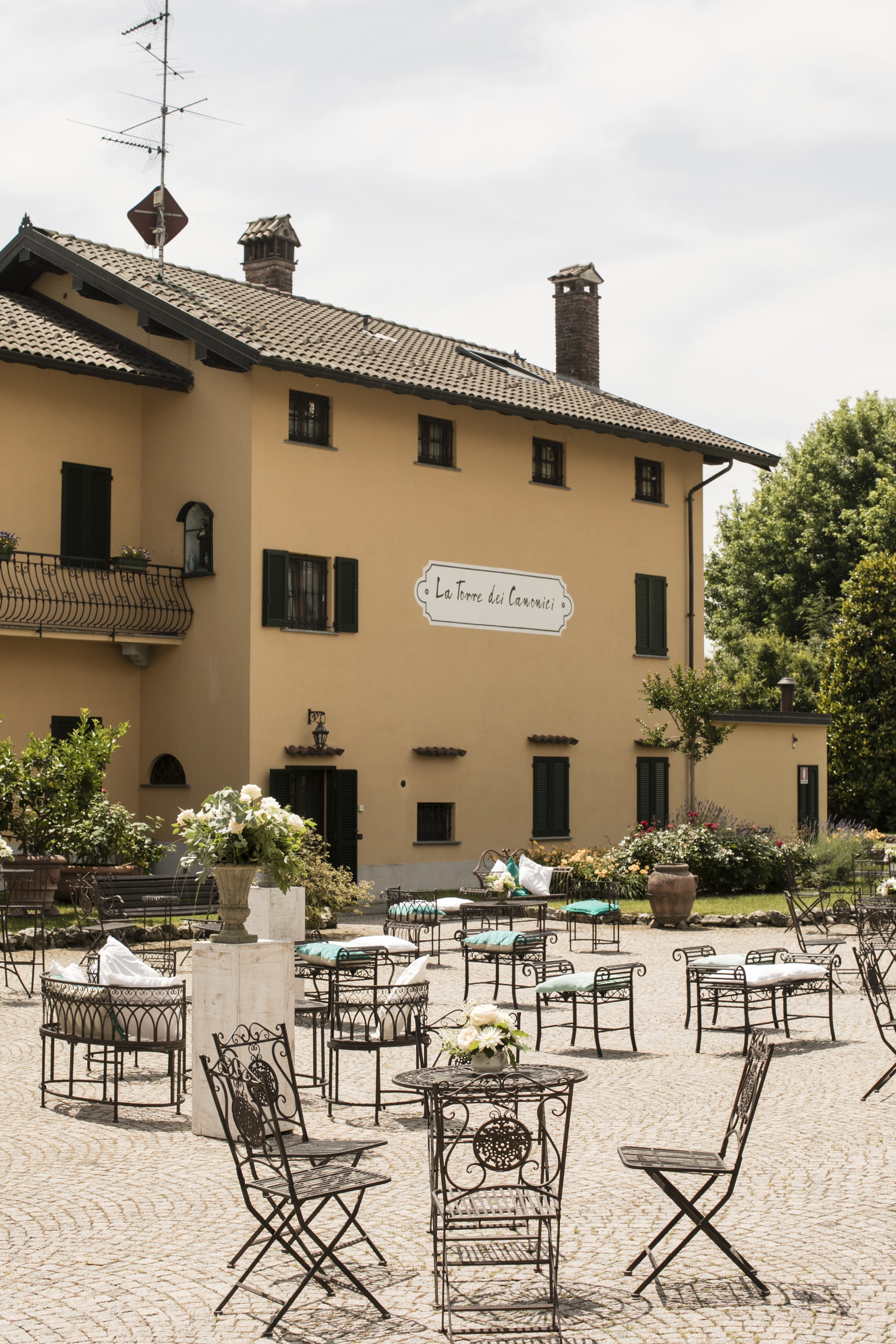 Cortile interno allestito con tavolini per un aperitivo, nella dimora del Quattrocento