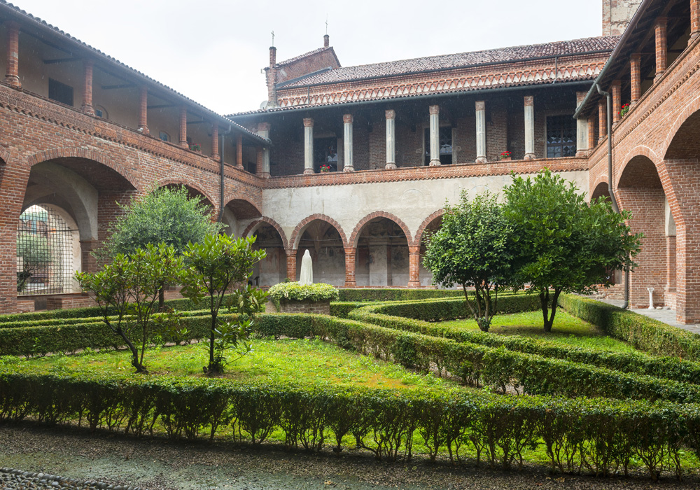 Chiostro medievale con portico ad arcate e giardino all'italiana, dimore storiche del novarese