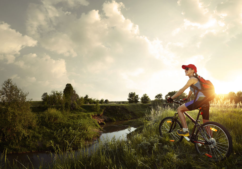 Un ospite in bicicletta al tramonto lungo un canale della campagna novarese