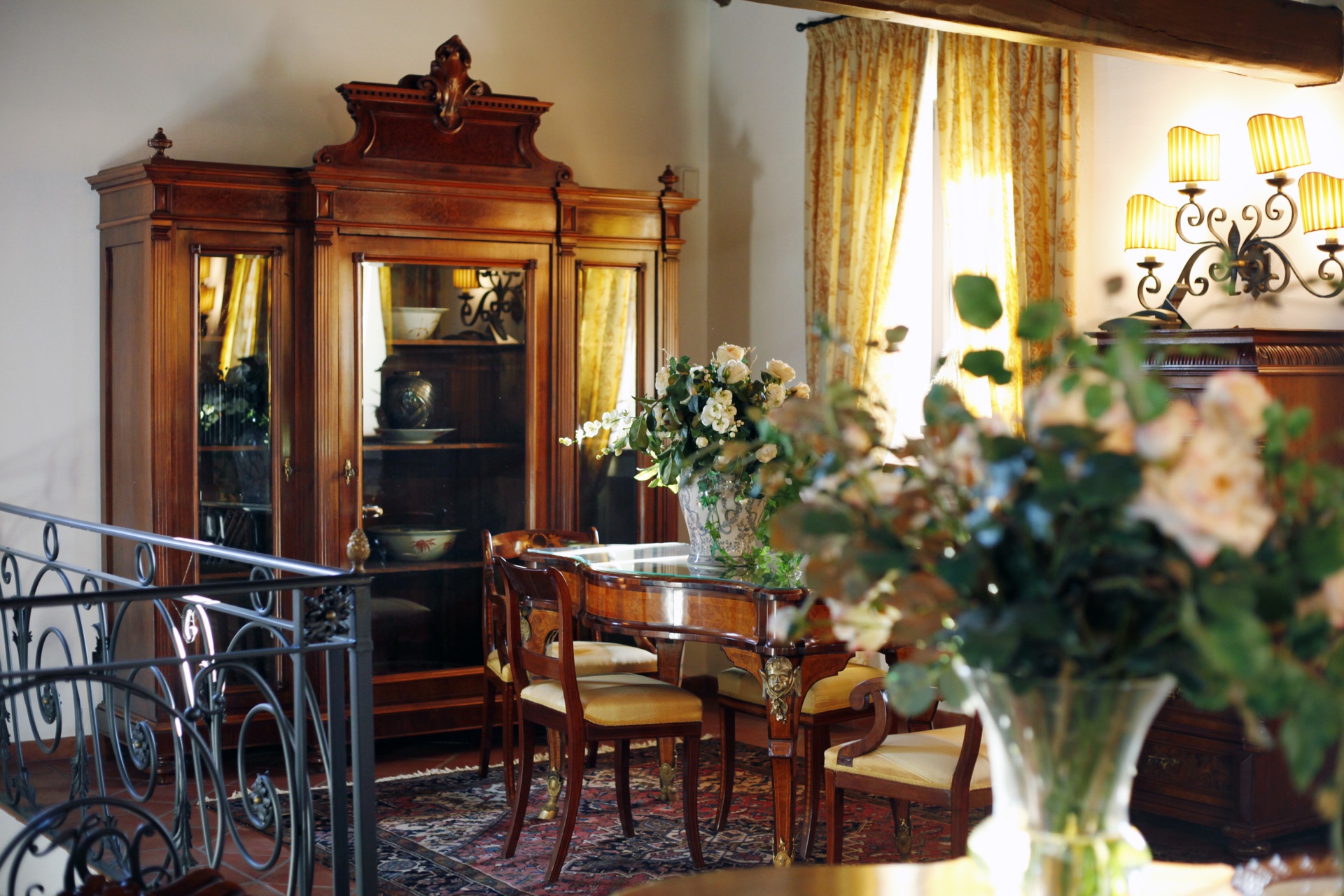 Sala riunioni in dimora storica alla Torre dei Canonici: vetrinetta in noce, rose fresche e lampadario in ferro battuto