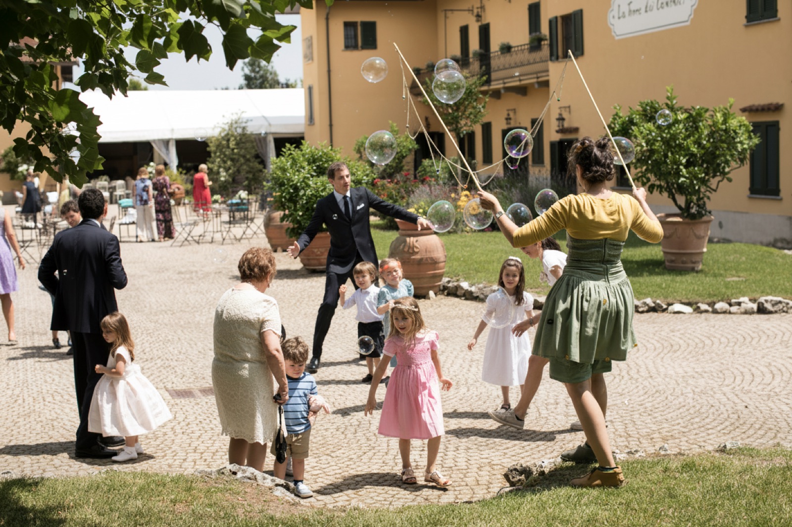 Bambini e invitati con bolle di sapone nel cortile della Torre dei Canonici